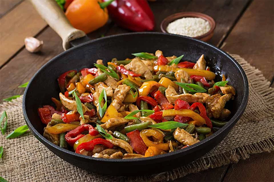 Colorful skillet of chicken and vegetables, representing an easy one-pan, nutritious holiday meal.