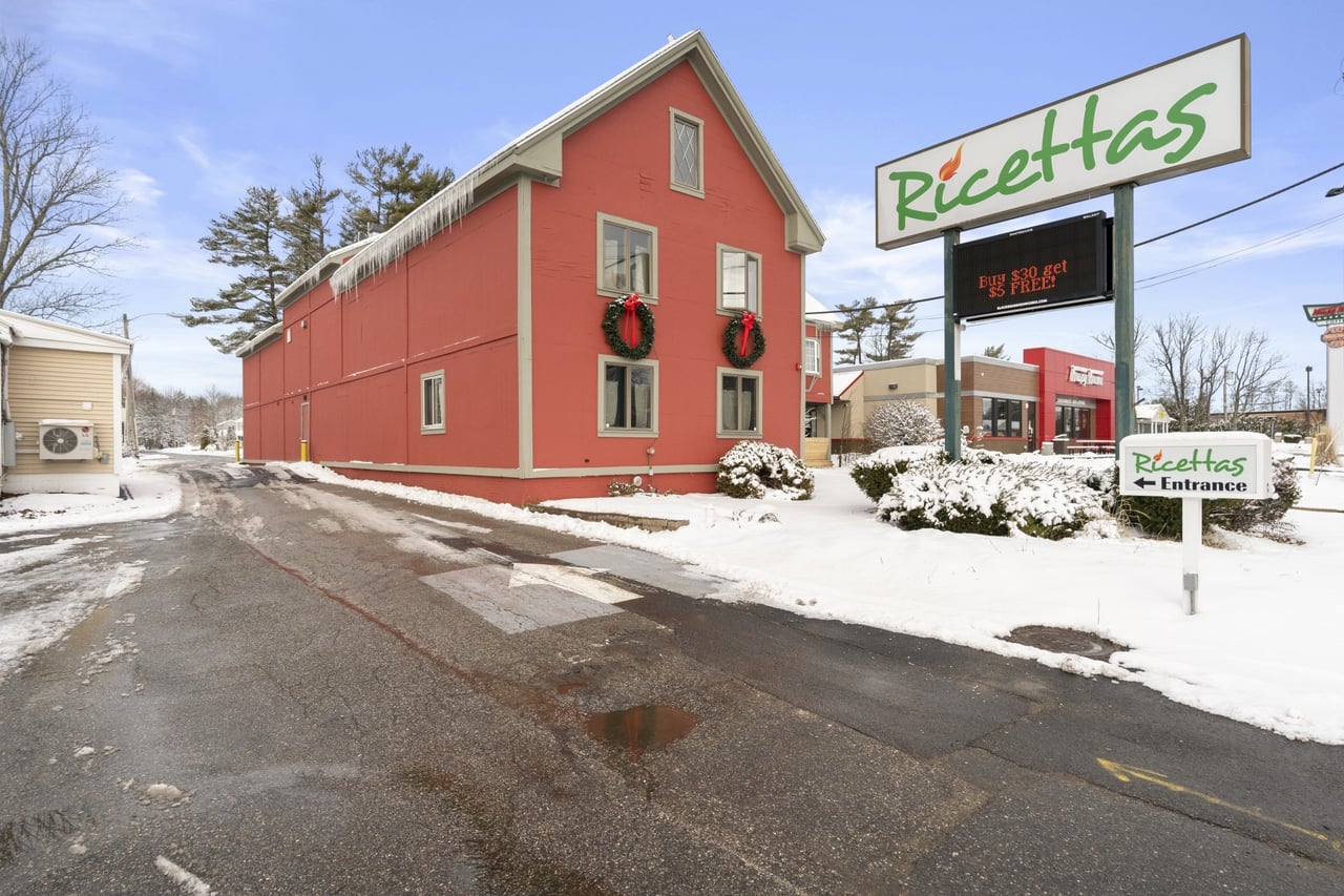 Exterior of Ricetta’s Brick Oven Ristorante during winter, showcasing the restaurant’s red building, holiday wreaths, and Ricetta’s signage.