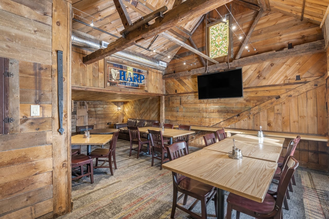 Interior view of Ricetta’s Brick Oven Ristorante featuring rustic wooden walls, exposed beams, and cozy seating arrangements.