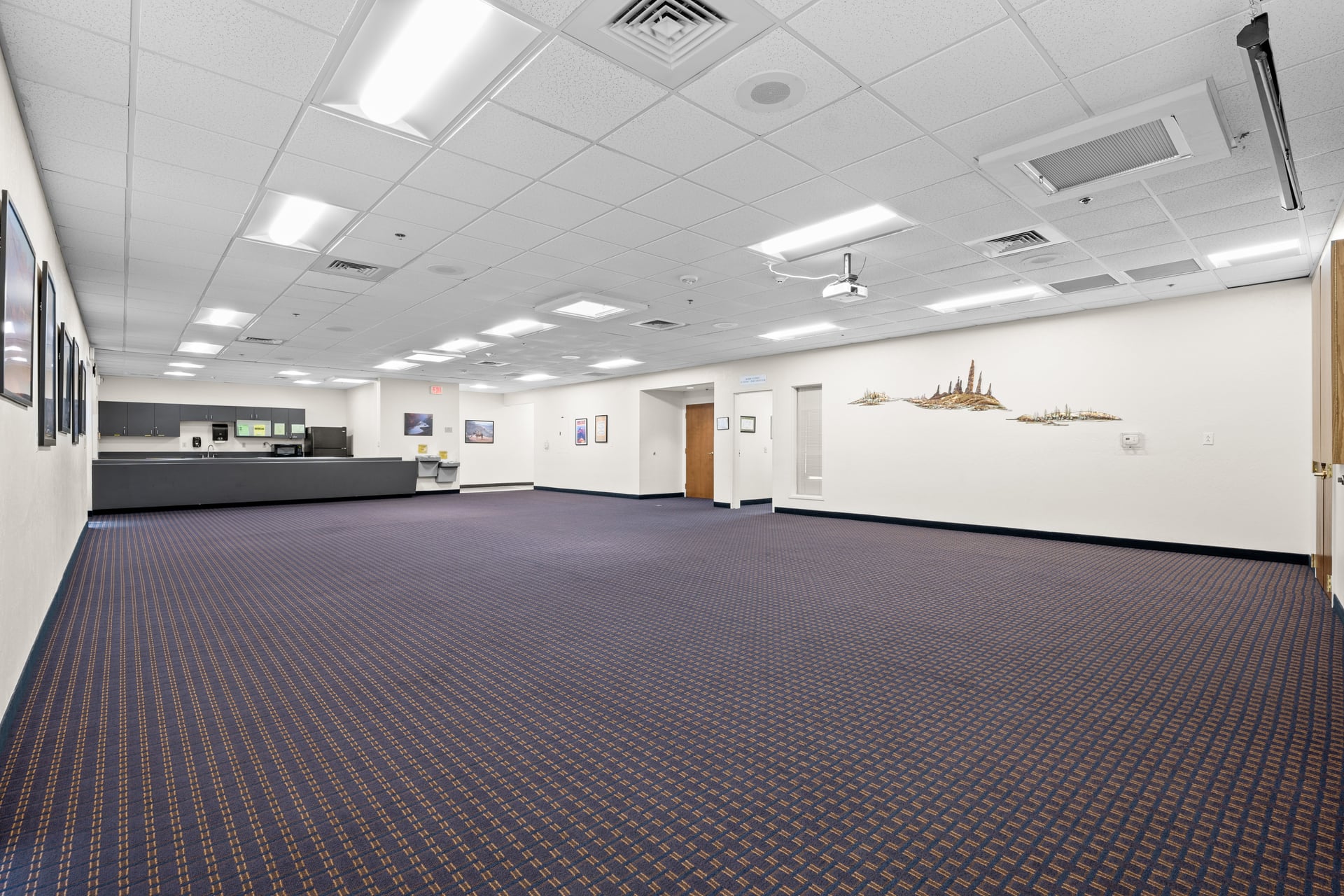 Recently updated event room with Arizona-themed wall art, LED lighting, and full kitchen access for larger social events.