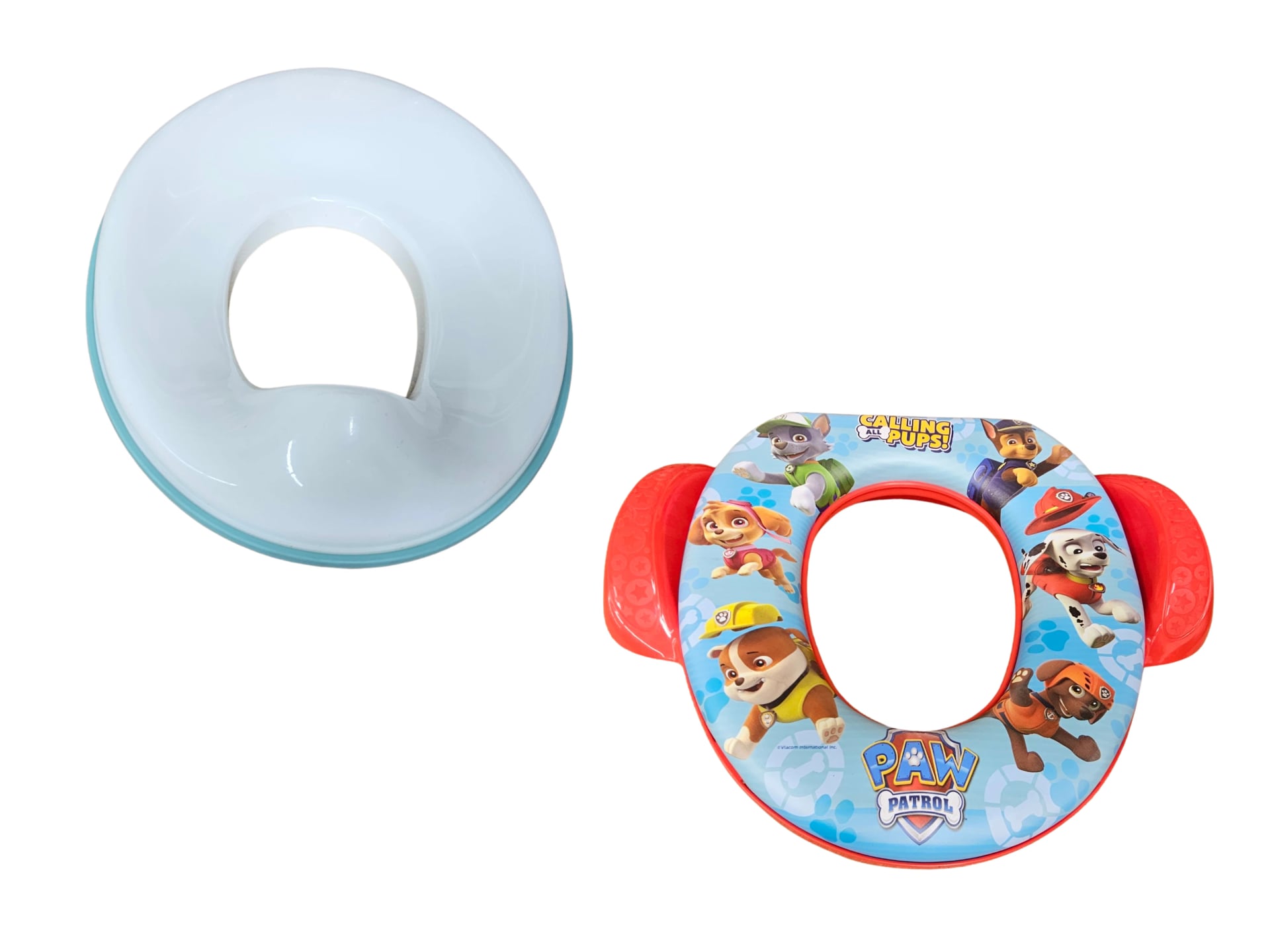 Two toddler toilet training seats displayed side by side. The left seat is a plain white oval with a blue base, while the right seat is colorful with red handles and decorated with Paw Patrol cartoon characters.