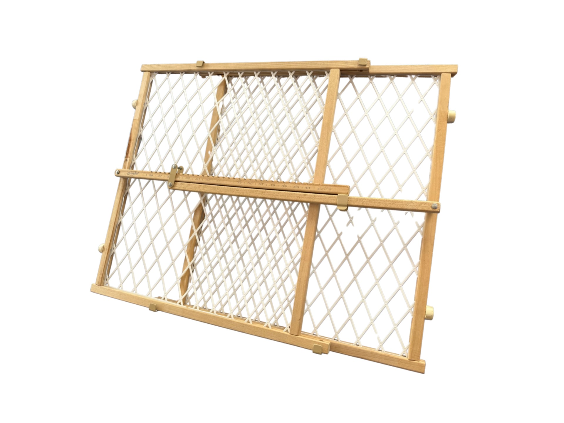 A wooden adjustable baby gate with a light wood frame and white plastic mesh lattice, shown partially expanded at an angle, with locking knobs visible on each side to secure the gate’s width.