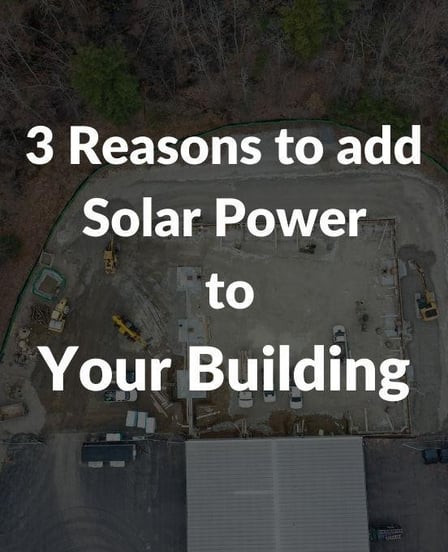 Aerial view of a commercial construction site with visible foundation work, surrounded by trees and machinery. White overlay text reads, “3 Reasons to Add Solar Power to Your Building.”