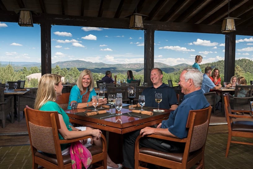 A group of people enjoying the rim club house with mountain views out the window